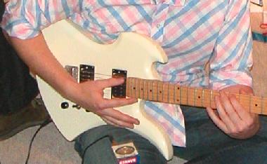 Chris, playing an electric guitar
